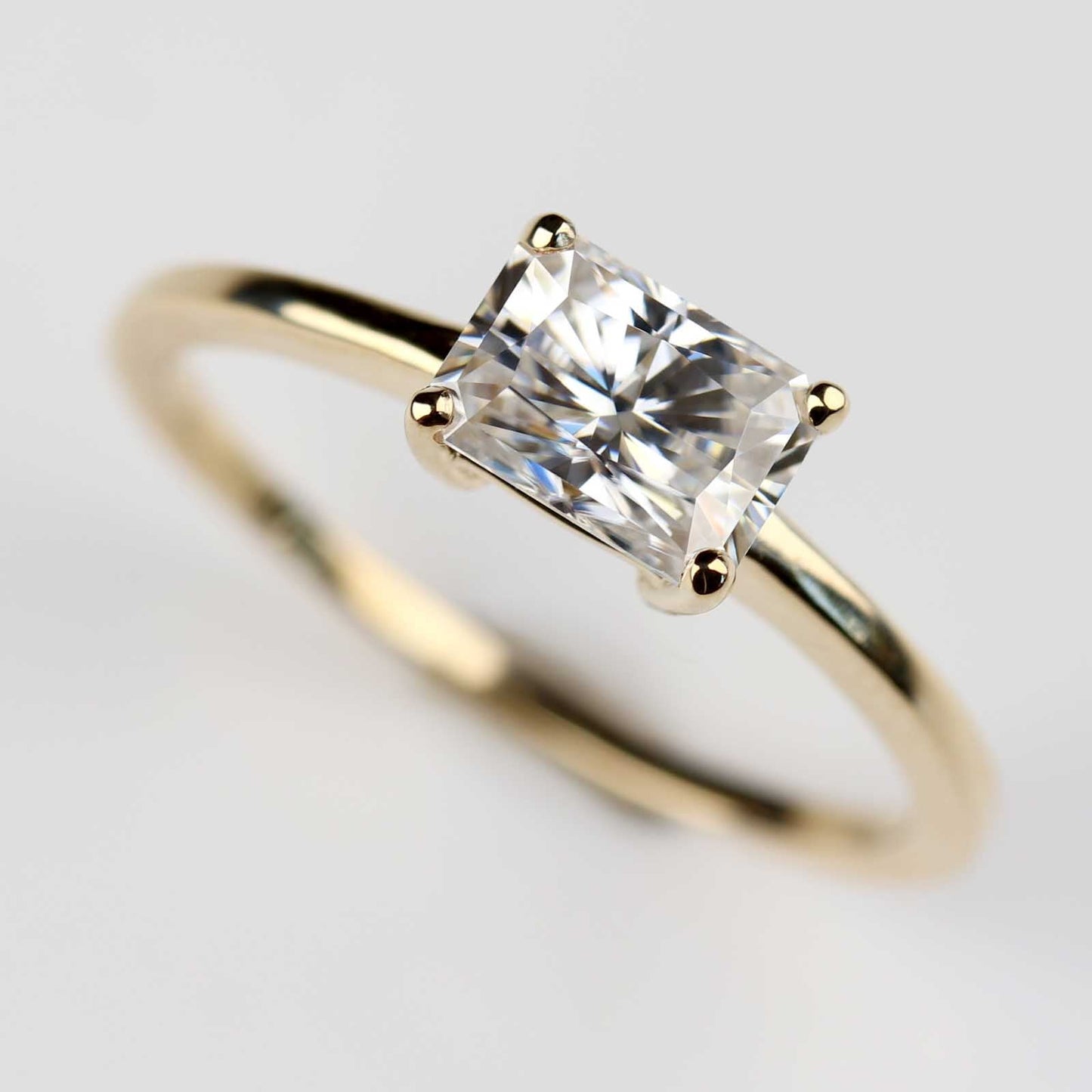 . 7x5mm Emerald Cut East-West Basket Solitaire Engagement Ring