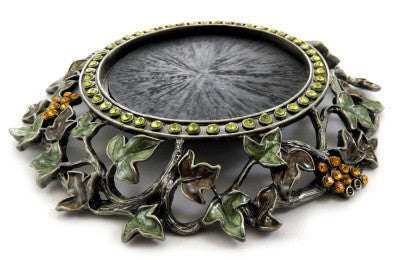 Round candle holder with filigree grape vine designs along the base ch1
